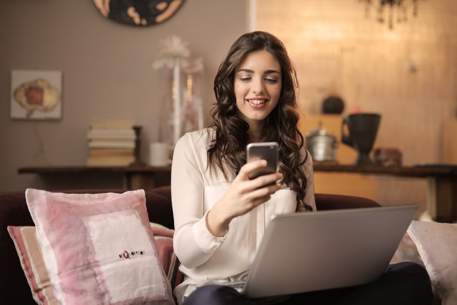 rsz_woman-sitting-on-sofa-while-looking-at-phone-with-laptop-on-920382_0f5f8133ac467e31dcdab3eb206208d9